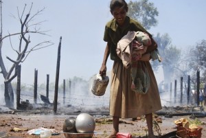 A Tamil refugee collects her belongings after fire broke out in a Tamil refugee camp in Vavuniya